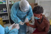 Des médecins militaires brésiliens effectuent un test sanguin sur un membre de l'ethnie Yanomami, en Amazonie brésilienne, le 1er juillet 2020 