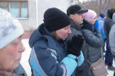 Des passants le 1er janvier 2019 à Magnitogorsk en Russie devant le site d'une explosion au gaz qui a ravagé un immeuble d'habitation