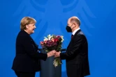 Le nouveau chancelier allemand Olaf Scholz remet un bouquet de fleurs à Angela Merkel lors de la passation de pouvoir à Berlin le 8 décembre 2021