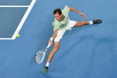 Le Russe Daniil Medvedev fait le grand écart pour renvoyer la balle de l'Espagnol Rafael Nadal lors de la finale de l'Open d'Australie, le 30 janvier 2022 à Melbourne