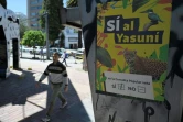 Un piéton passe devant une affiche appelant à l'arrêt de la production pétrolière dans la réserve amazonienne de Yasuni, le 18 août 2023.