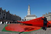 Un employé dévoile l'oeuvre des artistes néo-zélandais Helen Pollock et Tony Mcneight à Arras le 9 avril 2017