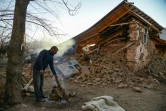 Un homme fait du feu près de sa maison effondrée après un séisme à Sivrice, le 25 janvier 2020 dans l'est de la Turquie, 