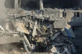 Des Palestiniens fouillent les décombres d'un bâtiment après une frappe israélienne, le 22 novembre 2024 à Gaza-ville dans la bande de Gaza