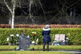 Une femme se tient devant la tombe de Gwen Mayor, une enseignante tuée lors d'une fusillade à Dunblane (Royaume-Uni) en 1996, le 12 mars 2021