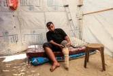 Majed-al-Imari, un déplacé palestinien de 32 ans amputé après des blessures durant le conflit en cours à Gaza fixe une prothèse dans une tente à Deir-al-Balah, dans le centre de la bande de Gaza, le 6 juillet 2024