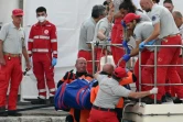 Les sauveteurs à la recherche des personnes portées disparues après le naufrage du superyacht de Mike Lynch en Sicile descendent à quai un sac mortuaire, à Porticello, près de Palerme, le 22 août 2024