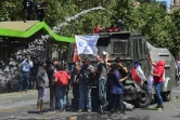 Des manifestants se tiennent devant un canon à eau de la police, à Santiago le 23 octobre 2019