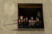 (g-d): Lourdes Ramos, Cristina Rios, Maria Luisa Prados et Ana Rubio, quatre jeunes médecins, aplaudissent les personnels soignants à la fenêtre de leur appartement à Madrid, le 28 avril 2020