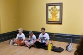 Photo fournie par l'organisation écologiste Just Stop Oil montrant trois militants devant un tableau des "Tournesols" de Vincent van Gogh aspergé de soupe, à la National Gallery à Londres, en septembre 2024