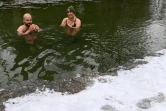 Erina Hey et Franz Mayr se baignent dans les eaux glaciales de la rivière Eisbach dans l'English Garden park de Munich, le 16 janvier 2021