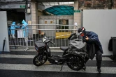 Un livreur en scooter apporte une commande à l'entrée d'un quartier confiné de Shanghai après l'apparition de nouveaux cas de Covid-19, le 17 mars 2022 en Chine