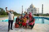 Un groupe de touristes prend des photos devant le Taj Mahal au premier jour de sa réouverture à Agra en Inde le 16 juin 2021