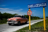 Une vieille voiture américaine face au panneau de Isabela de Sagua, à Cuba le 27 avril 2022