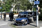 Des policiers près d'une voiture brûlée dans le quartier du Breil à Nantes le 4 juillet 2018