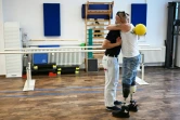 Vitaliy Saiko (D), un ex-soldat qui a perdu ses jambes pendant la guerre en Ukraine, est l'un des premiers patients à bénéficier d'un programme allemand de soins destiné aux amputés ukrainiens, le 25 juillet 2024 à Berlin