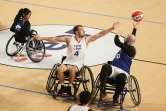 Denis Gargaud Chanut (c.), champion olympique de canoë-kayak en 2016, joue au basket-ball en fauteuil roulant lors d'une rencontre d'exhibition organisée au Palais des Sports de Bordeaux, le 23 novembre 2023
