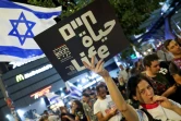 Une manifestante brandit une pancarte lors d'un rassemblement antigouvernemental appelant à agir pour obtenir la libération des otages israéliens retenus à Gaza, devant le ministère de la Défense à Tel-Aviv le 26 octobre 2024