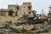 Photo du 24 mars 2019 de véhicules détruits et de bâtiments endommagés par les combats dans le village de Baghouz, dans l'est de la Syrie, au lendemain de la chute du "califat" du groupe jihadiste Etat islamique (EI)