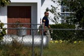 Un agent du FBI passe à côté d'une porte criblée d'impacts de balles à la First Baptist Church, le 7 novembre 2017 à Sutherland Springs, au Texas