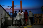 Des migrants regardent le soleil levant à bord de l'Aquarius en mer Méditerrannée le 16 août 2017