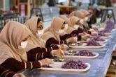 Des ouvrières nettoient des fleurs de crocus dans une usine de production de safran, le 12 novembre 2018 dans la province de Khorasan, en Iran