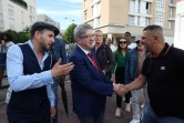 Le leader LFI Jean-Luc Mélenchon (c) rencontre des habitants lors d'une visite de soutien au candidat du Nouveau Front Populaire (NFP) aux législatives, Adel Amara (g), le 5 juillet 2024 à Villiers-sur-Marne, dans le Val-de-Marne