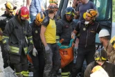 Des secouristes transportent un corps retrouvé parmi les décombres après le séisme dans le village de Illica, près de Accumoli, le 24 août  2016