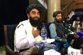 Le porte-parole des talibans Zabihullah Mujahid (g) lors de la première conférence de presse depuis leur prise du pouvoir à Kaboul, le 17 août 2021