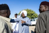 Idriss Ahmed Idriss (c), président de l’Association d'encouragement pour l'amélioration des races des chevaux du Tchad (AEARCT) parle avec d'autres membres avant la première course de la saison à l'hippodrome de Biligoni, le 30 novembre 2024 au Tchad