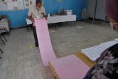 Un assesseur vérifie la liste des électeurs dans un bureau de vote en banlieue d'Alger, le 12 juin 2021