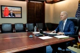 Le président américain Joe Biden (d) s'entretient avec son homologue chinois Xi Jinping (dans l'écran) par visioconférence depuis Washington, le 18 mars 2022