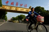 Une femme à vélo dans une rue de Huaxi, le 22 mai 2021 dans l'est de la Chine