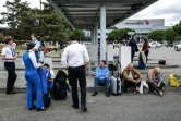 Les passagers et le personnel des compagnies aériennes attendent devant l'aéroport Toulouse-Blagnac, le 18 octobre 2023, après l'évacuation de l'aéroport