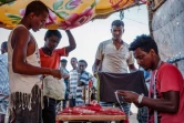 Une file d'attente se forme devant la boutique du tailleur éthiopien Omar Ibrahim, au camp d'Oum Raquba (Soudan) le 9 décembre 2020