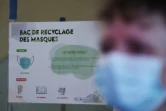 Une affiche d'information sur un bac de recyclage de masques dans un couloir de l'hôpital Saint-Antoine, le 30 avril 2021 à Paris
