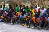 Des migrants attendent devant le centre d'accueil de Lampedusa, le 16 septembre 2023 en Italie