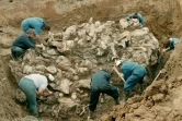 Des légistes du tribunal international pour les crimes de guerre à La Haye dégagent des corps partiellement décomposés trouvés dans une fosse commune, le 14 juillet 1996 à Pilica, au nord-est de Sarajevo