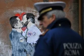 Un policier devant une peinture murale de l'artiste TVBOY représentant les leaders du MOUvement 5 EToiles Luigi de Maio et de la Ligue Matteo Salvini, le 23 mars 2018