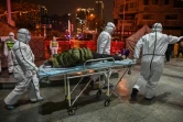 Des personnels médicaux transportent un patient présentant des symptômes du coronavirus à l'hôpital de la Croix-Rouge, le 25 janvier 2020 à Wuhan, en Chine