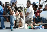 Des migrants attendent d'être débarqués d'un bateau des guardes-côtes italiens à leur arrivée le 7 août 2015 à Pozzalo en Italie