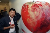 Le magnat de la presse et fondateur d'Apple Daily, Jimmy Lai, posant devant une affiche de pomme, à Hong Kong, le 14 juin 1995