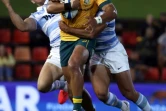 Les Argentins Matias Orlando (d) et Emiliano Boffelli tentent de plaquer l'Australien Jordan Petaia, lors de leur match comptant pour la 4e journée du Rugby Championship, le 21 novembre 2020 à Newcastle en Australie (Nouvelle-Galles du sud)
