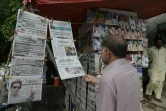 Un Pakistanais lit les titres de la presse dans un kiosque au lendemain des élections.