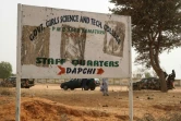 Des soldats passent devant un panneau signalant l'école de Dapchi, Nigeria, le 22 février 2018, trois jours après son attaque par Boko Haram