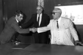 Photo d'archives montrant le président tunisien déchu Zine El Abidine Ben Ali (gauche), alors Premier ministre, serrant la main du président Habib Bourguiba (droite), le 1er janvier 1986 