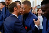 Le président Emmanuel Macron embrasse Kylian Mbappé en lui remettant la Légion d'honneur au Palais de l'Elysée à Paris le 4 juillet 2019 