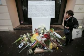 Une plaque commémorative et des fleurs devant l'entrée de la salle de concert le Bataclan à Paris, le 13 novembre 2016, un an après l'attaque qui a fait 90 morts
