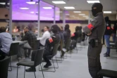 Des membres de la sécurité surveillent les accusés assis dans un box en verre, lors du procès des attentats de Bruxelles, le 25 juillet 2023 à Bruxelles