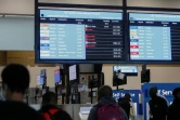 Des voyageurs devant un tableau d'affichage des vols annulés à l'aéroport international de Johannesburg, le 27 novembre 2021